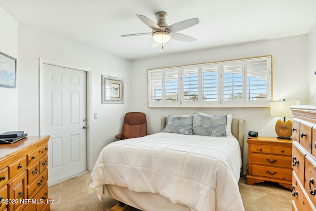 bedroom featuring light carpet and a ceiling fan