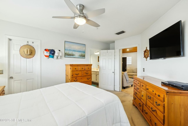 bedroom featuring ceiling fan, visible vents, and connected bathroom