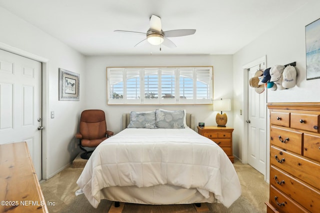 bedroom featuring baseboards, light colored carpet, and a ceiling fan