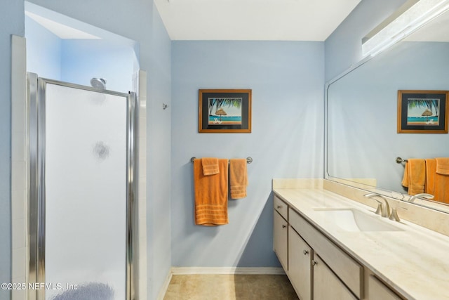 full bathroom featuring vanity, a shower stall, and baseboards