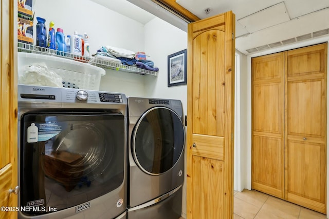 laundry area featuring separate washer and dryer, light tile patterned flooring, and laundry area