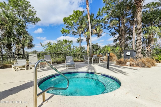 view of pool featuring a patio area, fence, and a hot tub