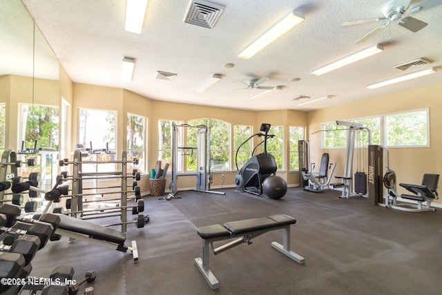 gym with baseboards, visible vents, and a textured ceiling