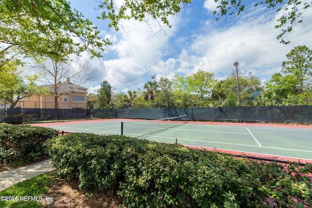 view of tennis court featuring fence