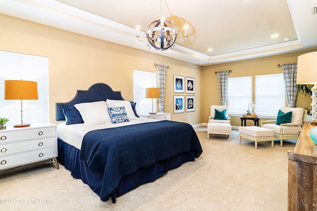 bedroom featuring a chandelier, a raised ceiling, and carpet