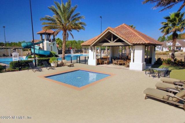 view of swimming pool with a playground, a patio area, a gazebo, and a water slide