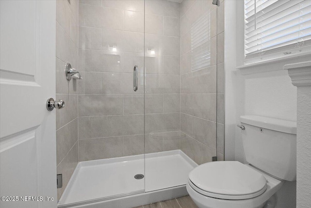 full bath featuring a shower stall and toilet