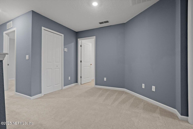 unfurnished bedroom featuring a closet, visible vents, baseboards, and carpet floors