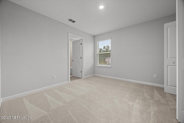 unfurnished bedroom with carpet flooring, baseboards, visible vents, and a textured ceiling