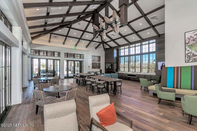 dining room featuring wood finished floors, french doors, and a towering ceiling