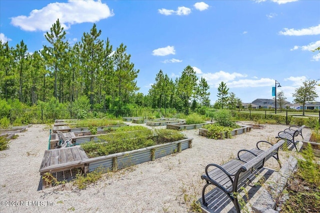 surrounding community featuring a vegetable garden and fence