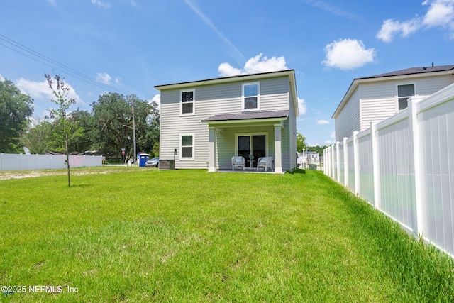 rear view of house featuring a lawn and a patio area