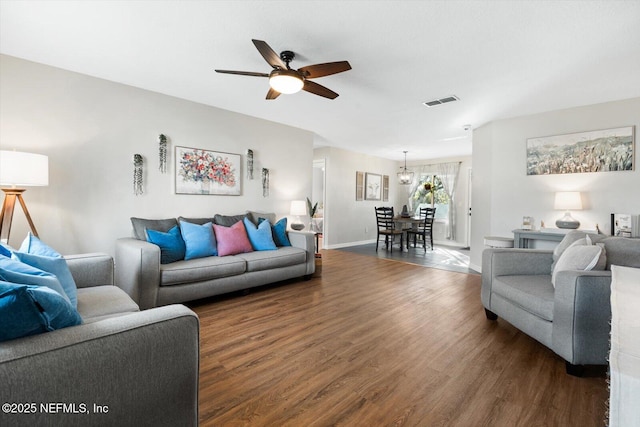 living room featuring dark wood-type flooring and ceiling fan