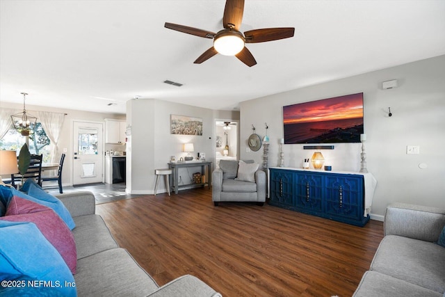 living room featuring dark hardwood / wood-style flooring and ceiling fan with notable chandelier