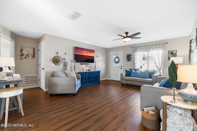 living room featuring dark wood-type flooring and ceiling fan