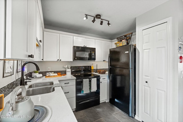 kitchen featuring sink, white cabinetry, a textured ceiling, dark tile patterned floors, and black appliances