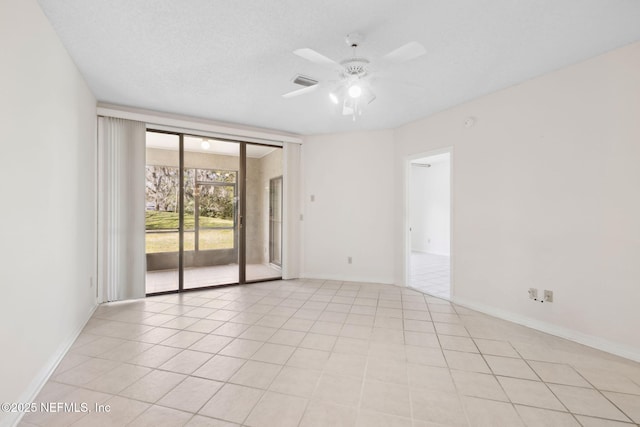 spare room featuring light tile patterned floors, ceiling fan, baseboards, and a textured ceiling