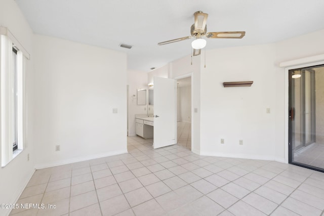 unfurnished room featuring light tile patterned floors, visible vents, a ceiling fan, plenty of natural light, and baseboards