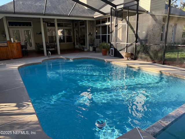 outdoor pool featuring glass enclosure, french doors, a patio, and a ceiling fan