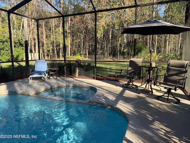 view of swimming pool with a pool with connected hot tub, a lanai, a patio, and a forest view