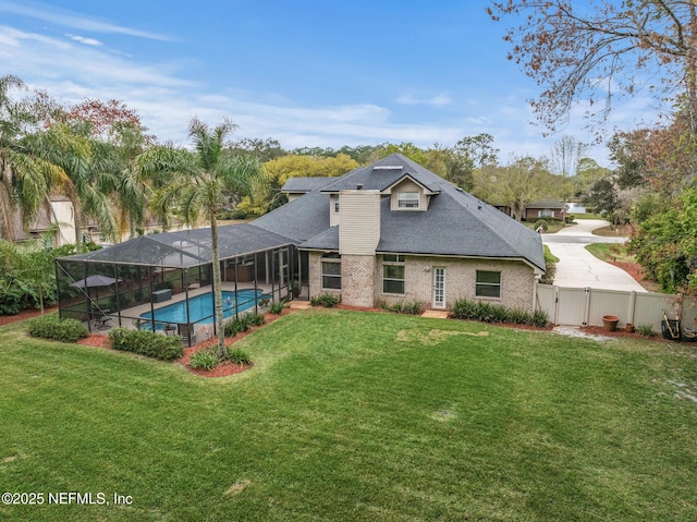 back of house with a yard, brick siding, a gate, and a fenced in pool