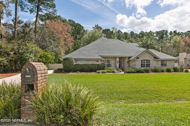 view of front of home featuring a front lawn, roof with shingles, and fence