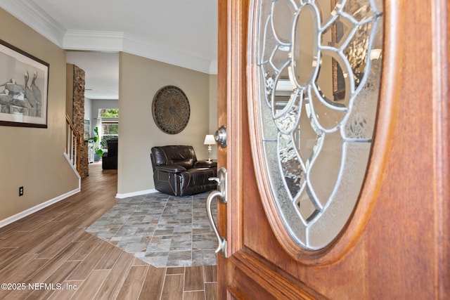 foyer with stairs, baseboards, crown molding, and wood finish floors