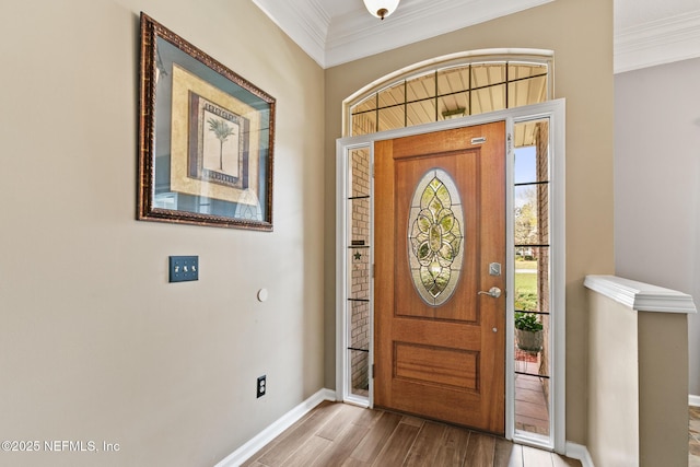 entrance foyer featuring ornamental molding, baseboards, and wood finished floors