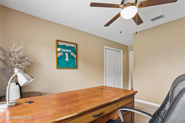 office space with carpet floors, visible vents, ceiling fan, and baseboards