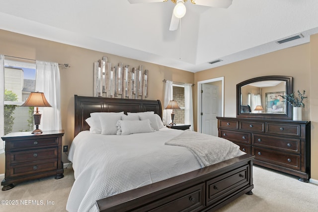 bedroom featuring light carpet, lofted ceiling, visible vents, and a ceiling fan