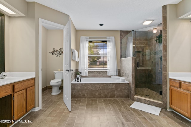 full bath featuring a bath, toilet, a shower stall, and vanity