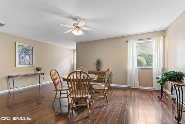 dining room with visible vents, a textured ceiling, baseboards, and wood finished floors