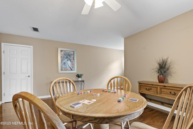 dining space with visible vents, ceiling fan, baseboards, and wood finished floors