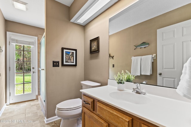 bathroom with a shower with shower door, a healthy amount of sunlight, vanity, and toilet