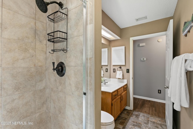 full bath with toilet, vanity, visible vents, baseboards, and a stall shower