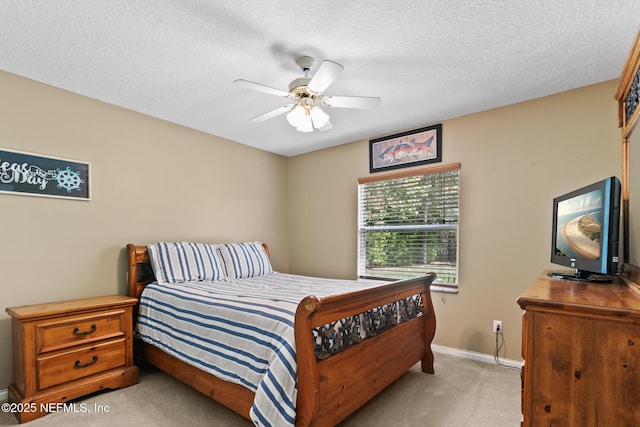 bedroom featuring light carpet, a ceiling fan, baseboards, and a textured ceiling