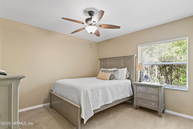 bedroom with light carpet, baseboards, and a ceiling fan