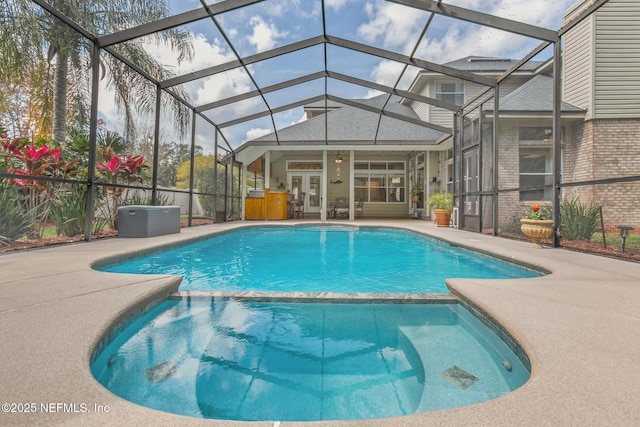 view of swimming pool featuring a lanai, a patio area, a pool with connected hot tub, and french doors