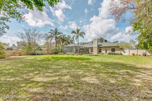 view of yard with glass enclosure and a fenced backyard