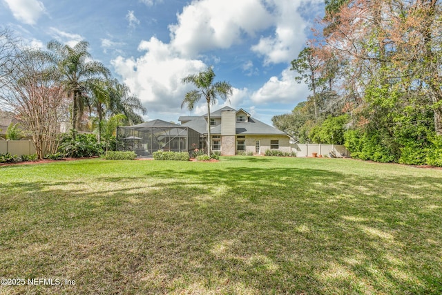 view of yard featuring glass enclosure and a fenced backyard