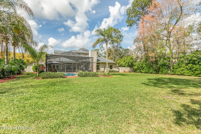 view of yard featuring glass enclosure and fence