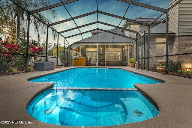 view of swimming pool with a lanai, a pool with connected hot tub, and a patio