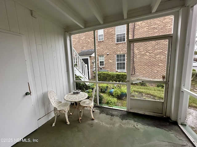 unfurnished sunroom with beam ceiling