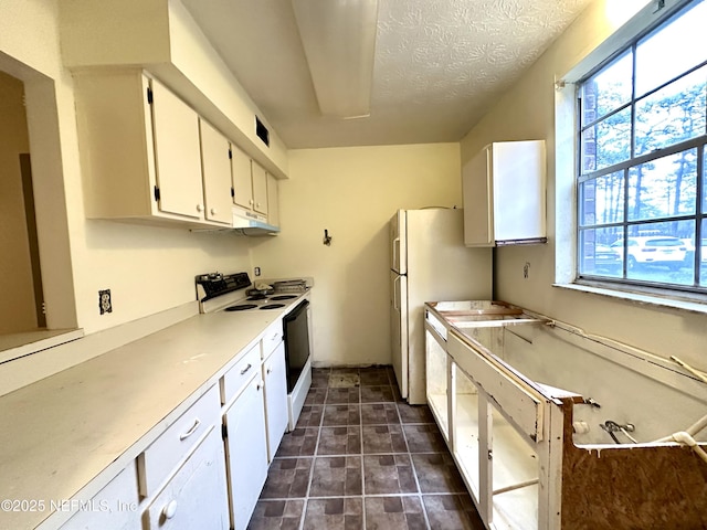 kitchen featuring a textured ceiling, white electric range oven, white cabinets, and dishwashing machine