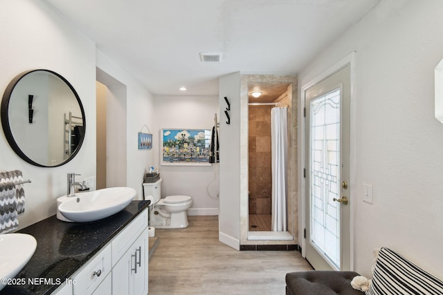 bathroom featuring curtained shower, vanity, toilet, and hardwood / wood-style floors