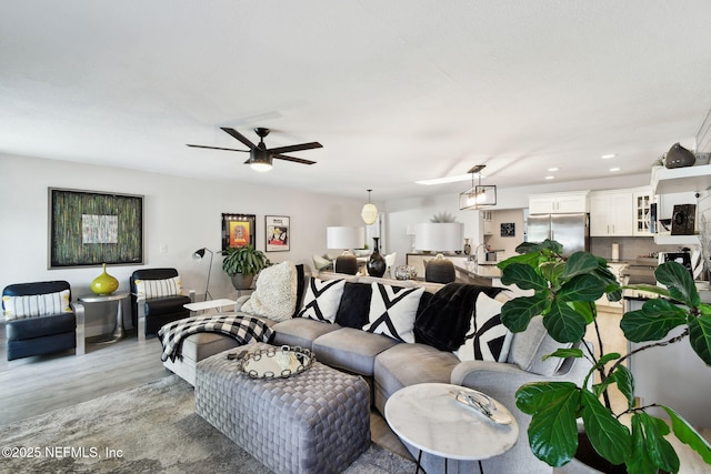 living room with light hardwood / wood-style floors and ceiling fan