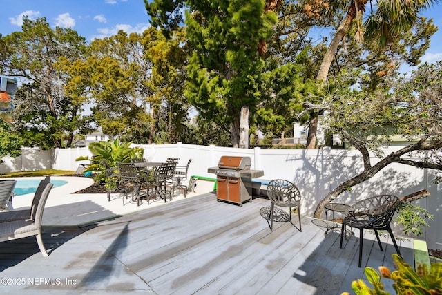 deck featuring grilling area and a fenced in pool