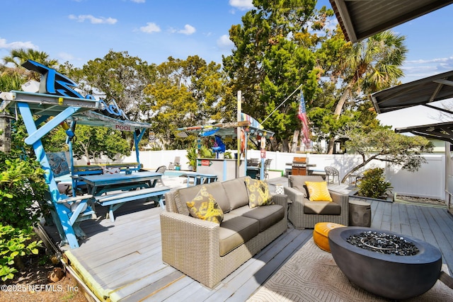 wooden terrace featuring a swimming pool and an outdoor living space with a fire pit