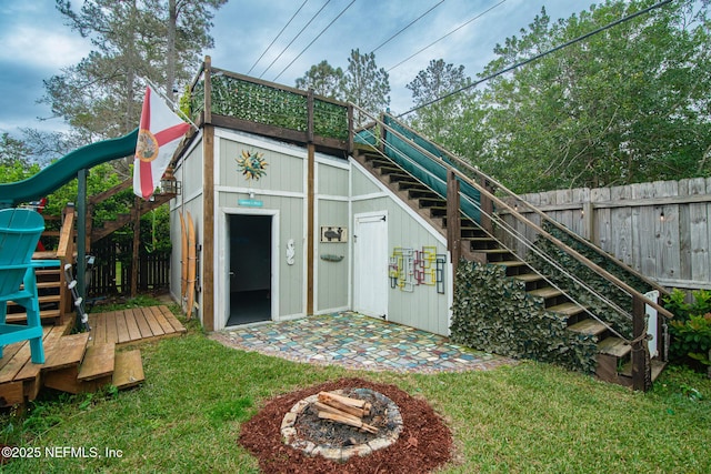 view of outdoor structure featuring stairway and fence