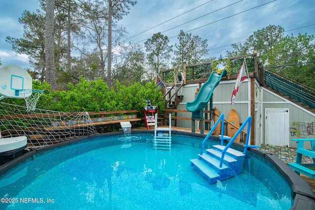 view of swimming pool featuring a playground